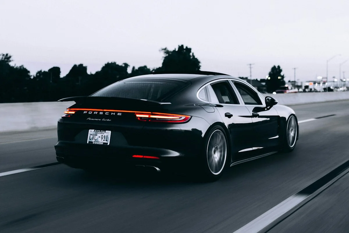 Dunkle Sportlimousine auf einer Straße, illustratives Fahrzeugmotiv